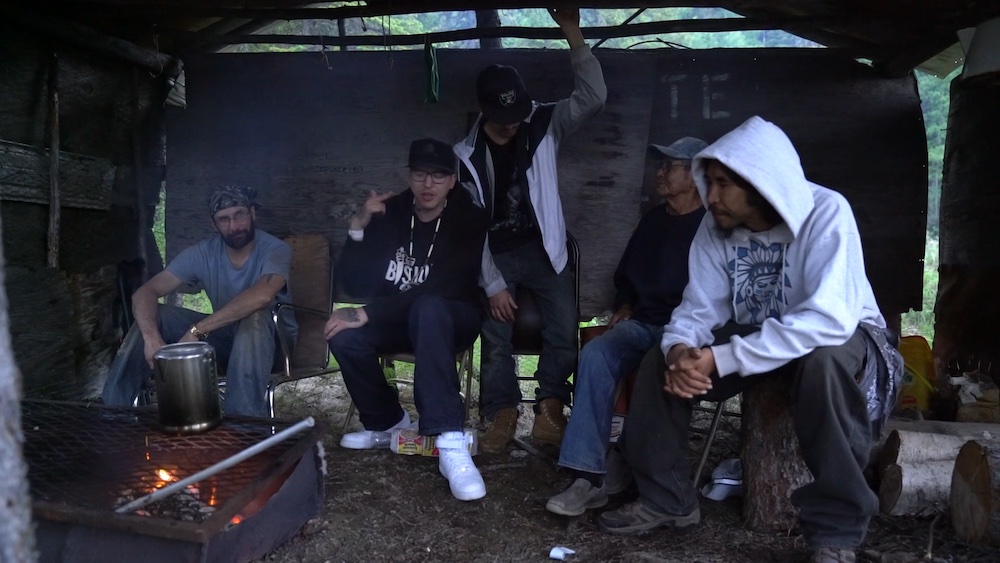 Bishop Slice rapping "Bibles and Bullets" at the campfire in his grandma's smoke house